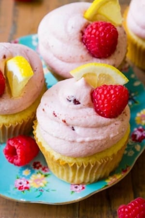 lemon cupcakes with raspberry frosting on a blue floral plate
