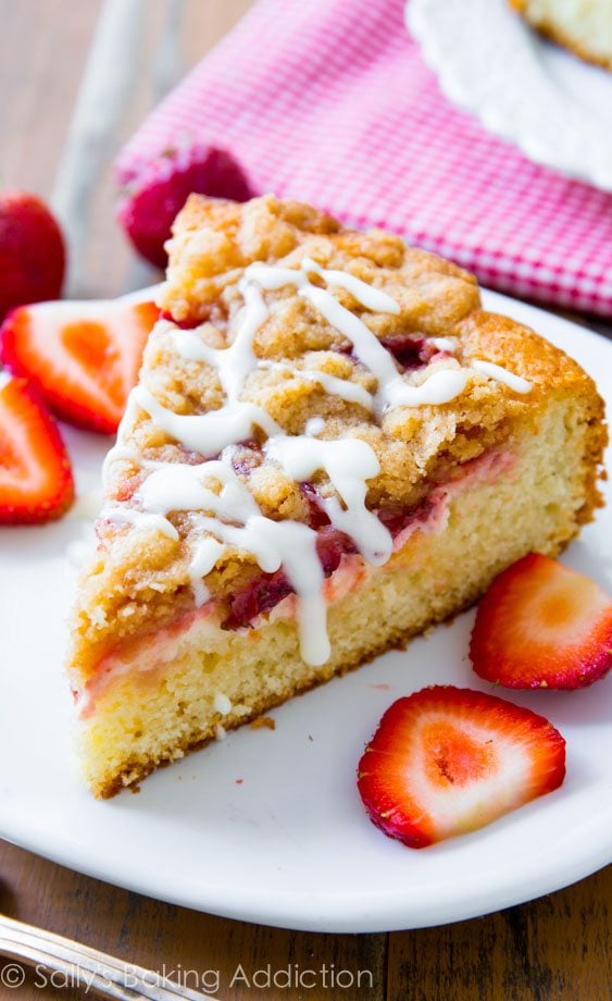 Strawberries 'n Cream Crumb Cake complete with a buttery cake, sweet strawberries, cheesecake filling, and vanilla glaze! Recipe by sallysbakingaddiction.com