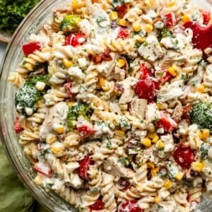 large glass bowl of chicken pasta salad with creamy dressing all over it.