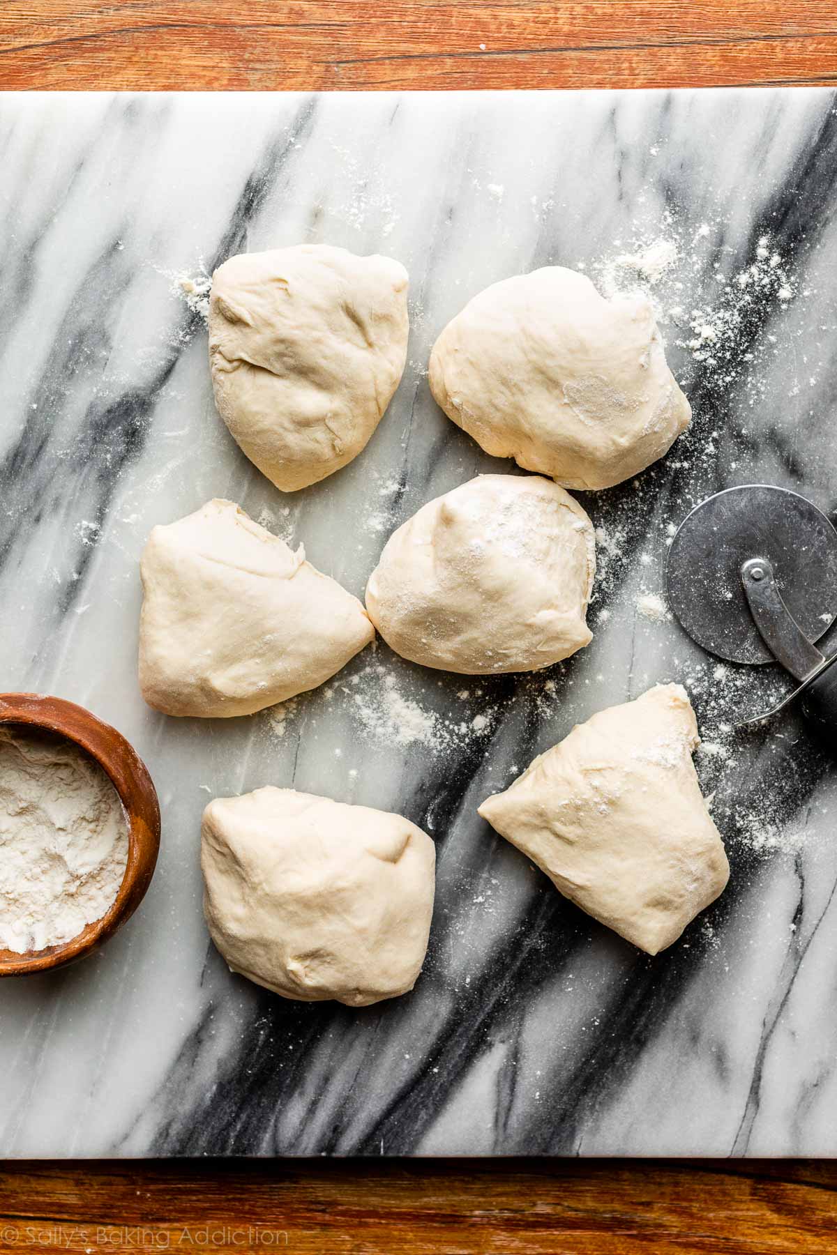 6 pieces of dough shown on a marble cutting board