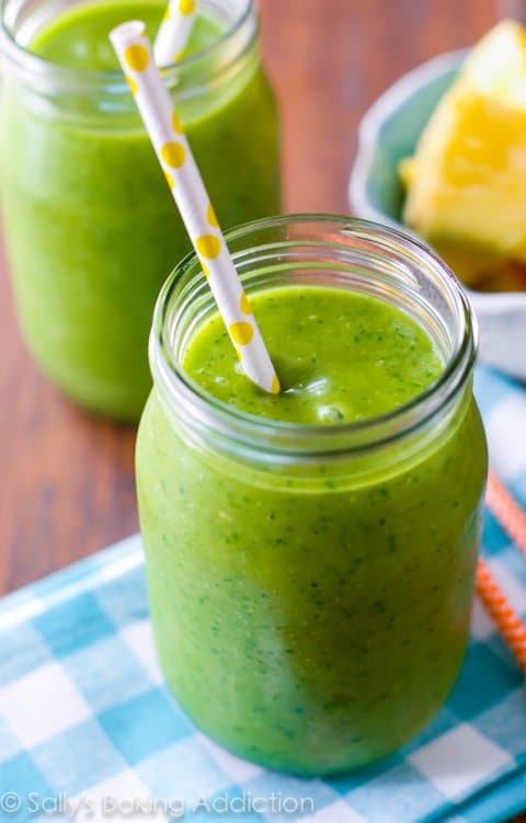 green smoothie in glasses with straws