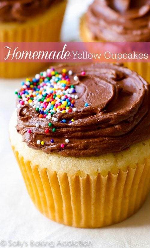 yellow cupcakes topped with milk chocolate frosting and sprinkles
