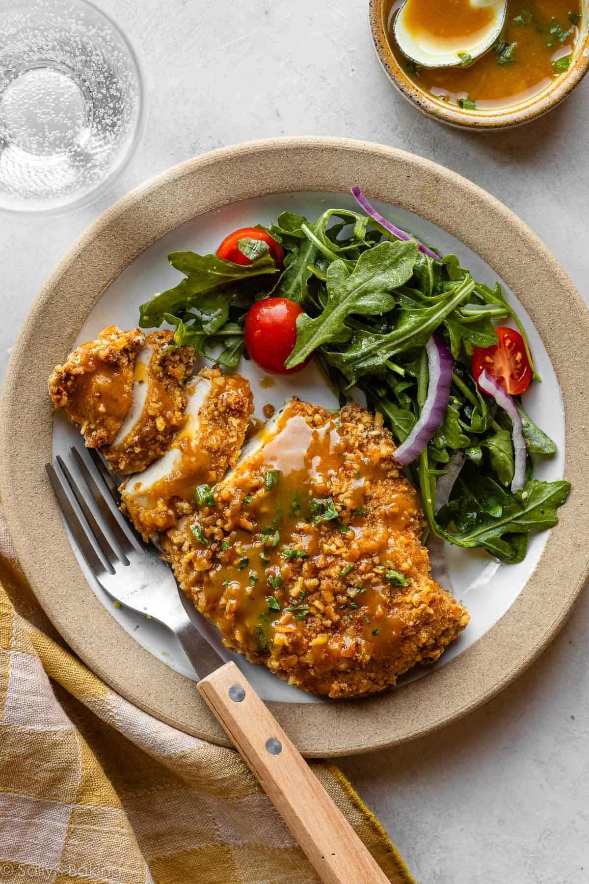 pretzel-crusted chicken on a plate with salad.