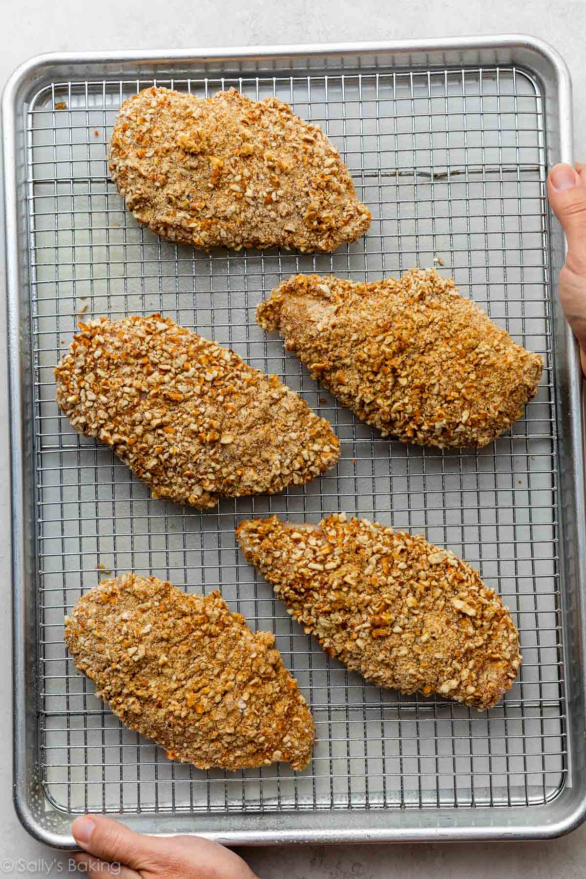 pretzel-crusted chicken on a rack on a baking sheet.