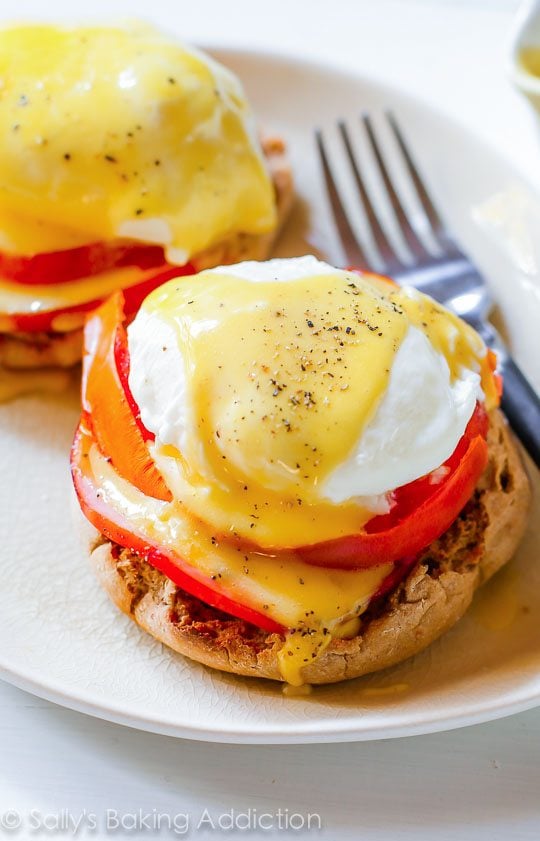 eggs benedict on a white plate with a fork
