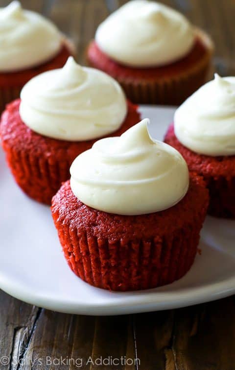 red velvet cupcakes with cream cheese frosting on a white plate