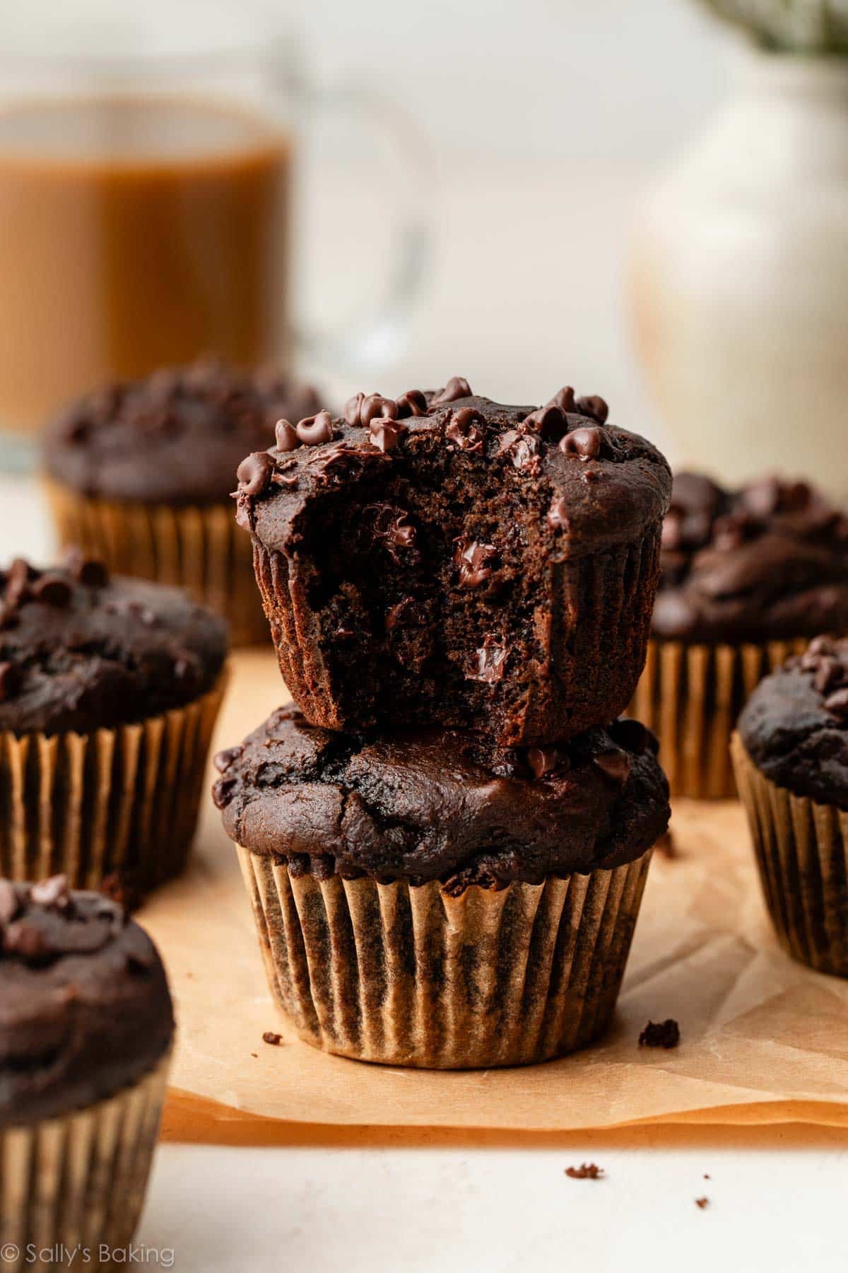chocolate muffins stacked, with a bite taken out of one.