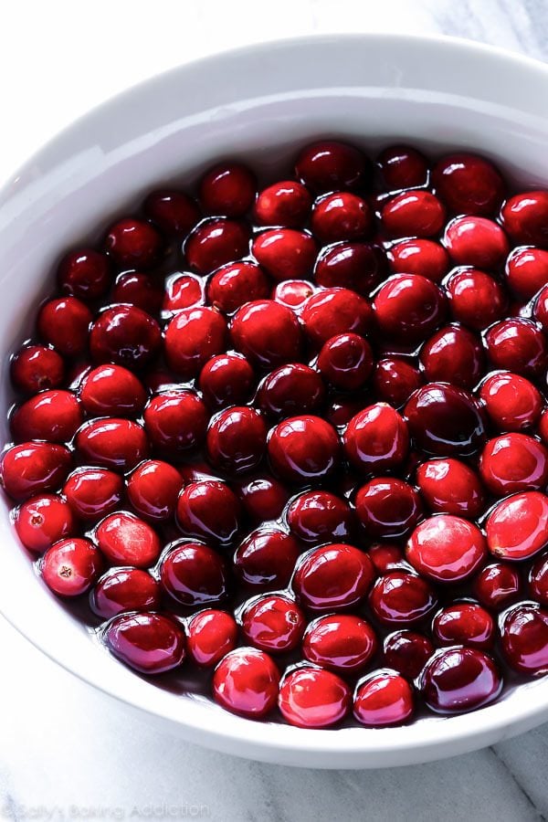 fresh cranberries in a bowl of sugar syrup