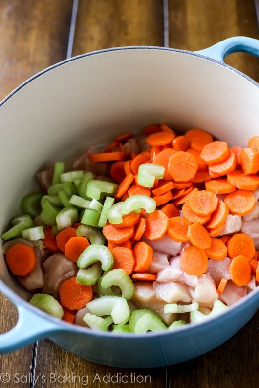 chicken, celery, and carrots in a blue pot