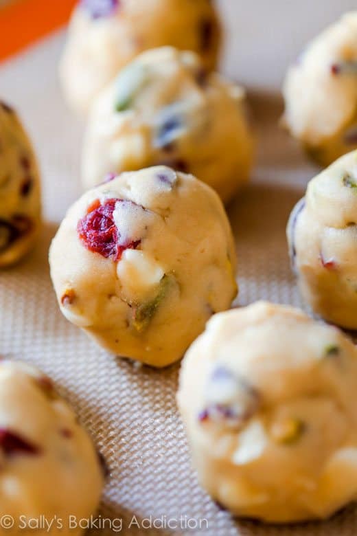 white chocolate cranberry pistachio cookie dough balls on a silpat baking mat