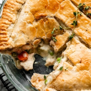 chicken pot pie in glass dish with slice removed.