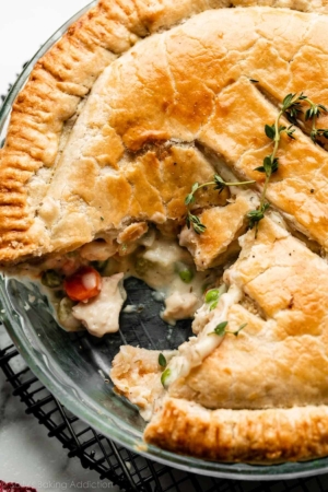 chicken pot pie in glass dish with slice removed.