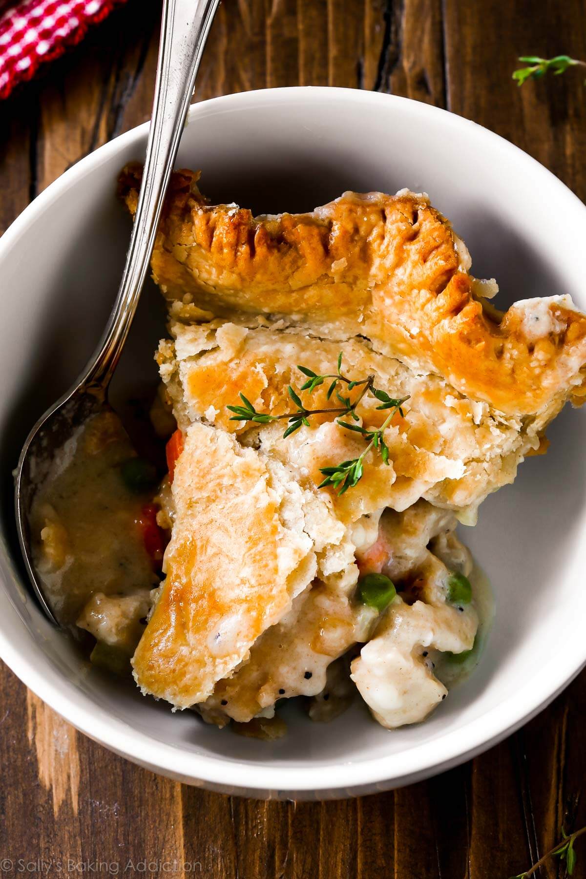 slice of chicken pot pie in a white bowl with a spoon
