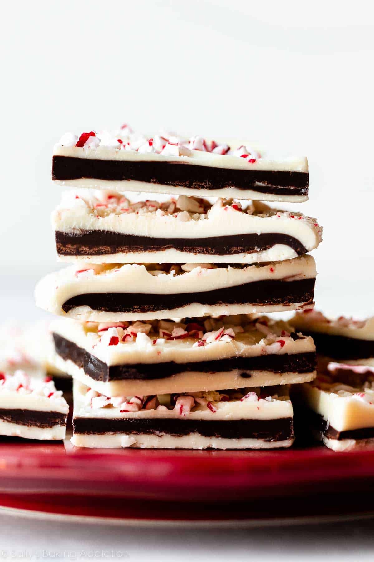 stack of peppermint bark pieces on red plate.