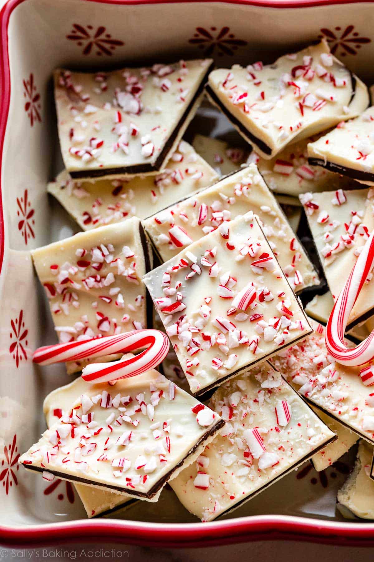 peppermint bark with crushed candy canes on top in a red and white baking dish.
