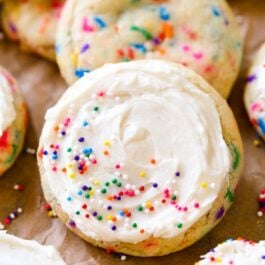 sugar cookies with sprinkles topped with vanilla frosting and sprinkles