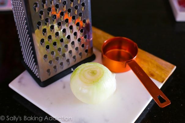 onion on a cutting board with a grater