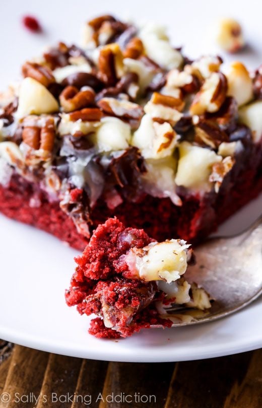 red velvet seven layer bar on a white plate with a fork