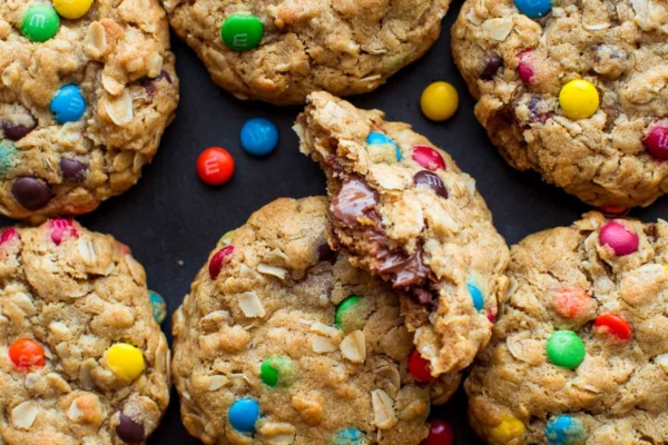 overhead image of monster cookies with one cookie broken in half showing a peanut butter cup inside
