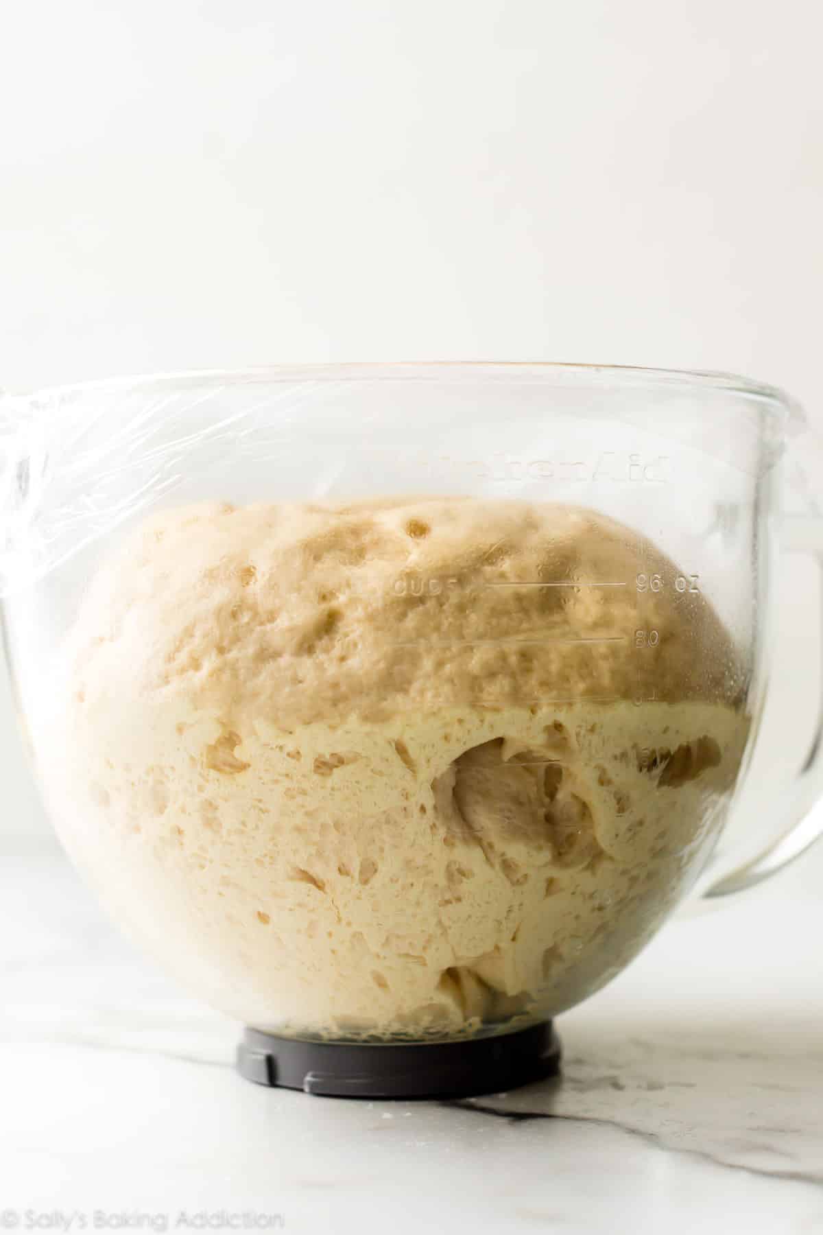 dough that has doubled in size pictured in a glass bowl