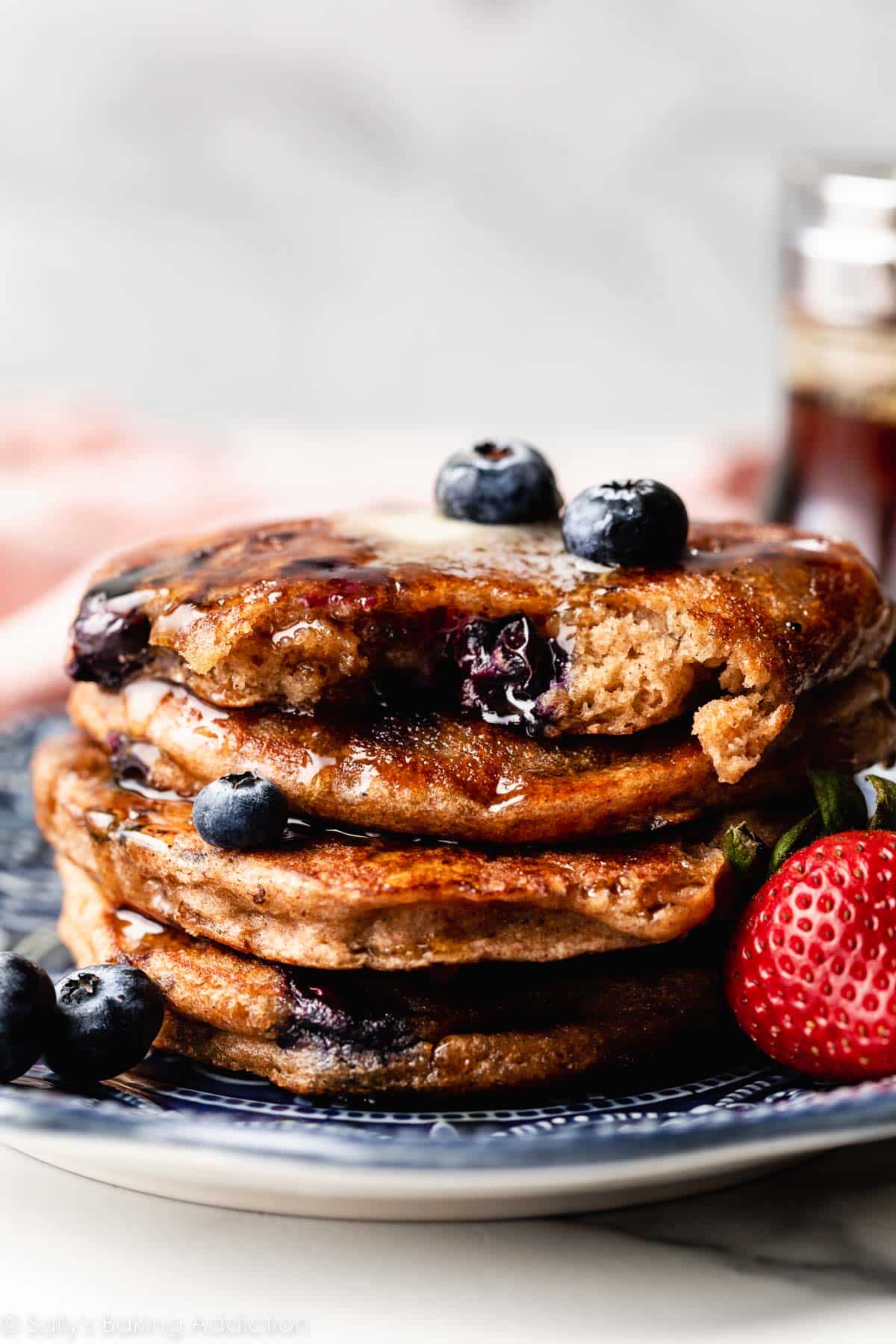 stack of blueberry pancakes with fresh blueberries on top.