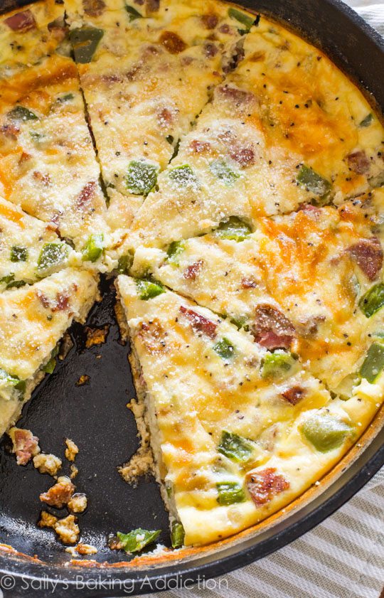 overhead image of cheesy sausage quiche in a pan with one slice removed