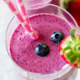 berry smoothies in glasses with straws