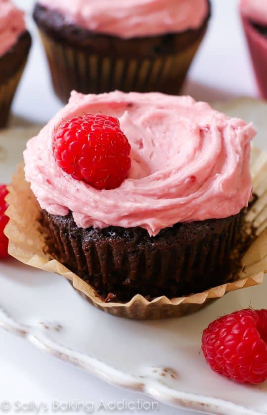 chocolate cupcakes topped with raspberry frosting and raspberries
