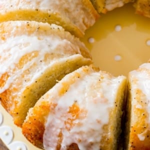 overhead image of lemon poppy seed bundt cake cut into slices on a yellow plate