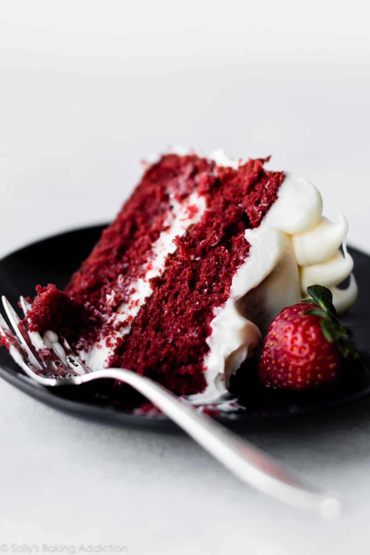 slice of red velvet cake on a black plate