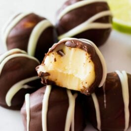dark chocolate key lime pie truffles with a bite taken from one showing the inside