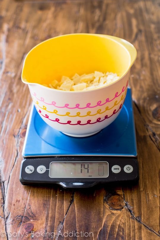 white chocolate chunks in a bowl on a food scale
