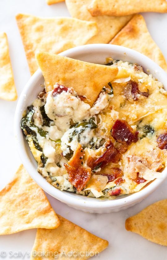roasted garlic bacon spinach dip in a white ramekin with pita chips