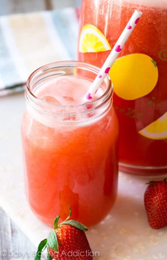 glass of honey sweetened strawberry lemonade with a straw