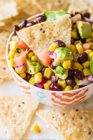 avocado corn salsa in a colorful bowl with chips
