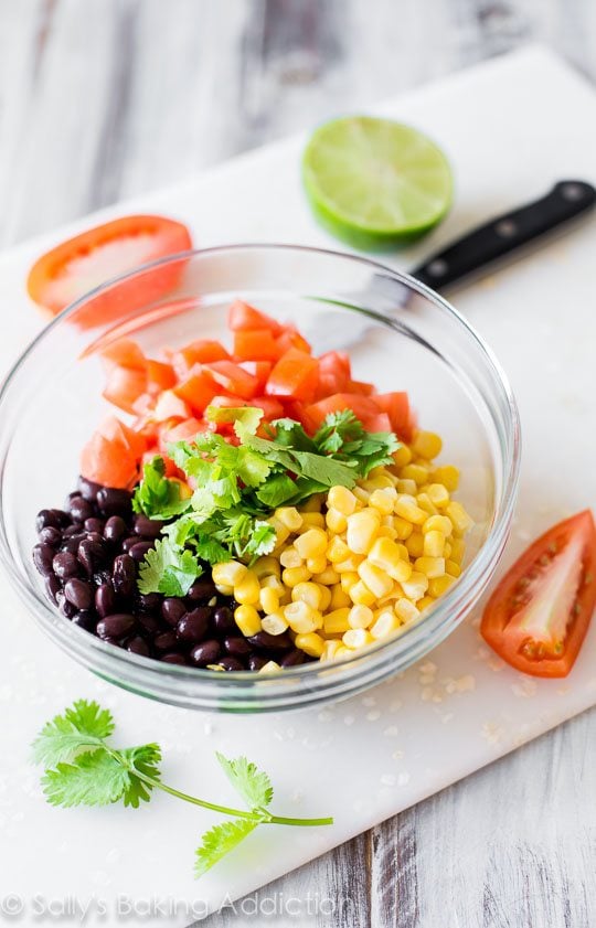 ingredients for corn and avocado salsa in a glass bowl