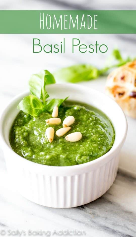 basil pesto in a white bowl topped with pine nuts
