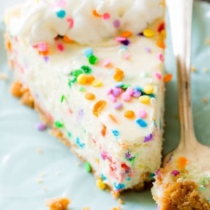 slice of funfetti cheesecake on a blue plate with a fork