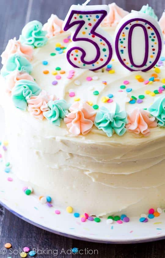 funfetti layer cake on a serving plate with a 3 and 0 candles