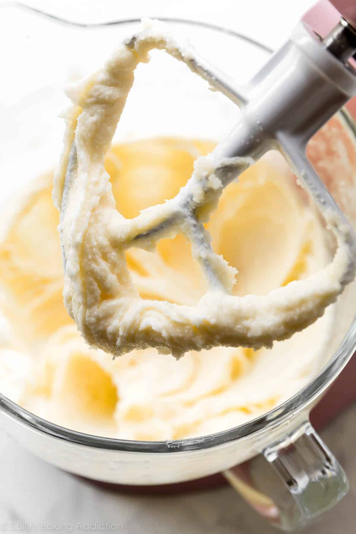 photo showing up-close detail of creamed butter, sugar, and oil mixture on flat beater attachment.