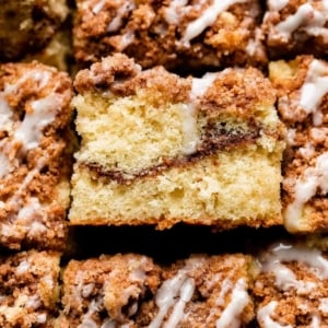 up close photo showing cinnamon coffee cake with 1 slide turned on side to see ribbon of cinnamon swirl inside.