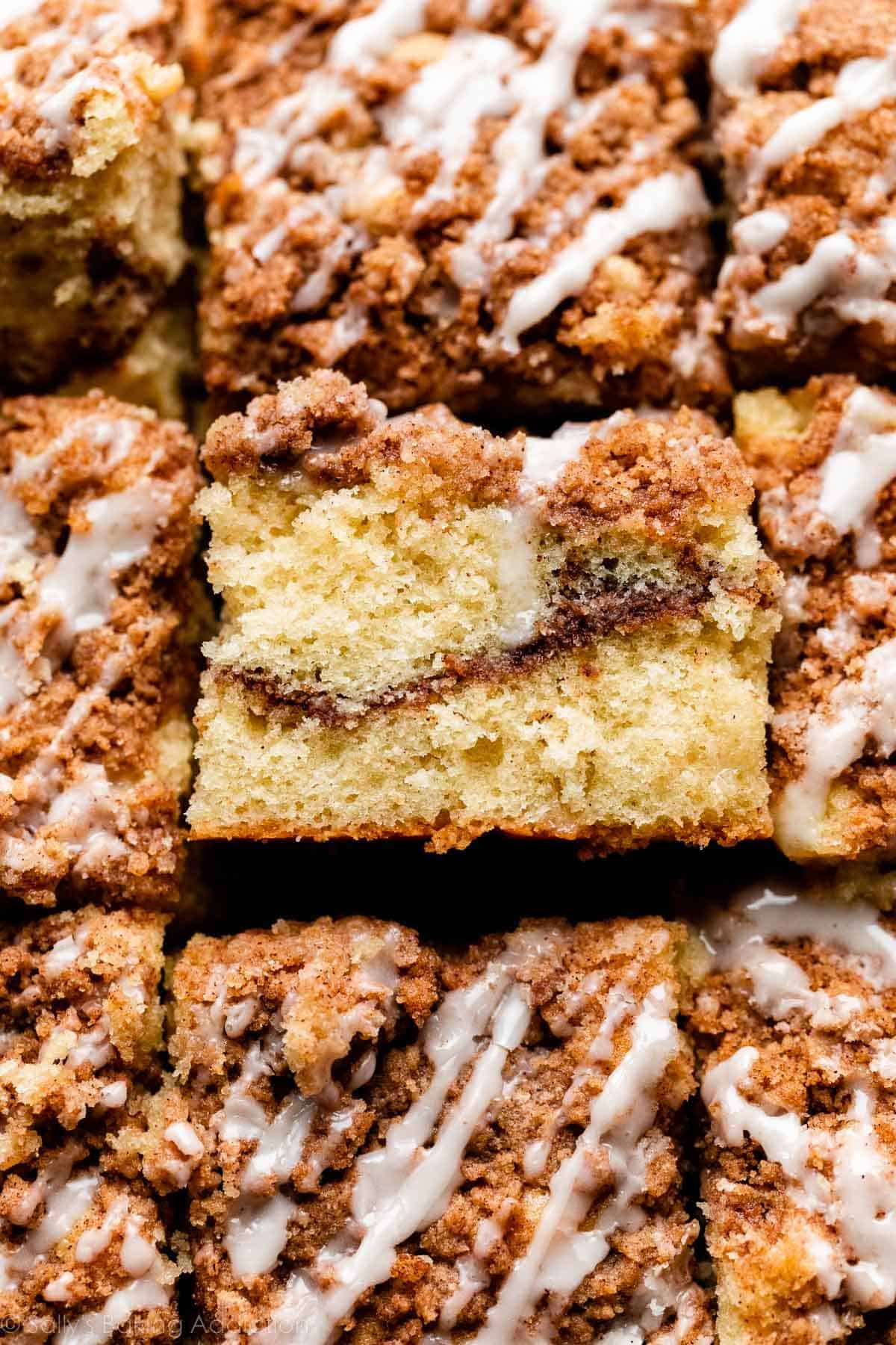 up close photo showing cinnamon coffee cake with 1 slide turned on side to see ribbon of cinnamon swirl inside.