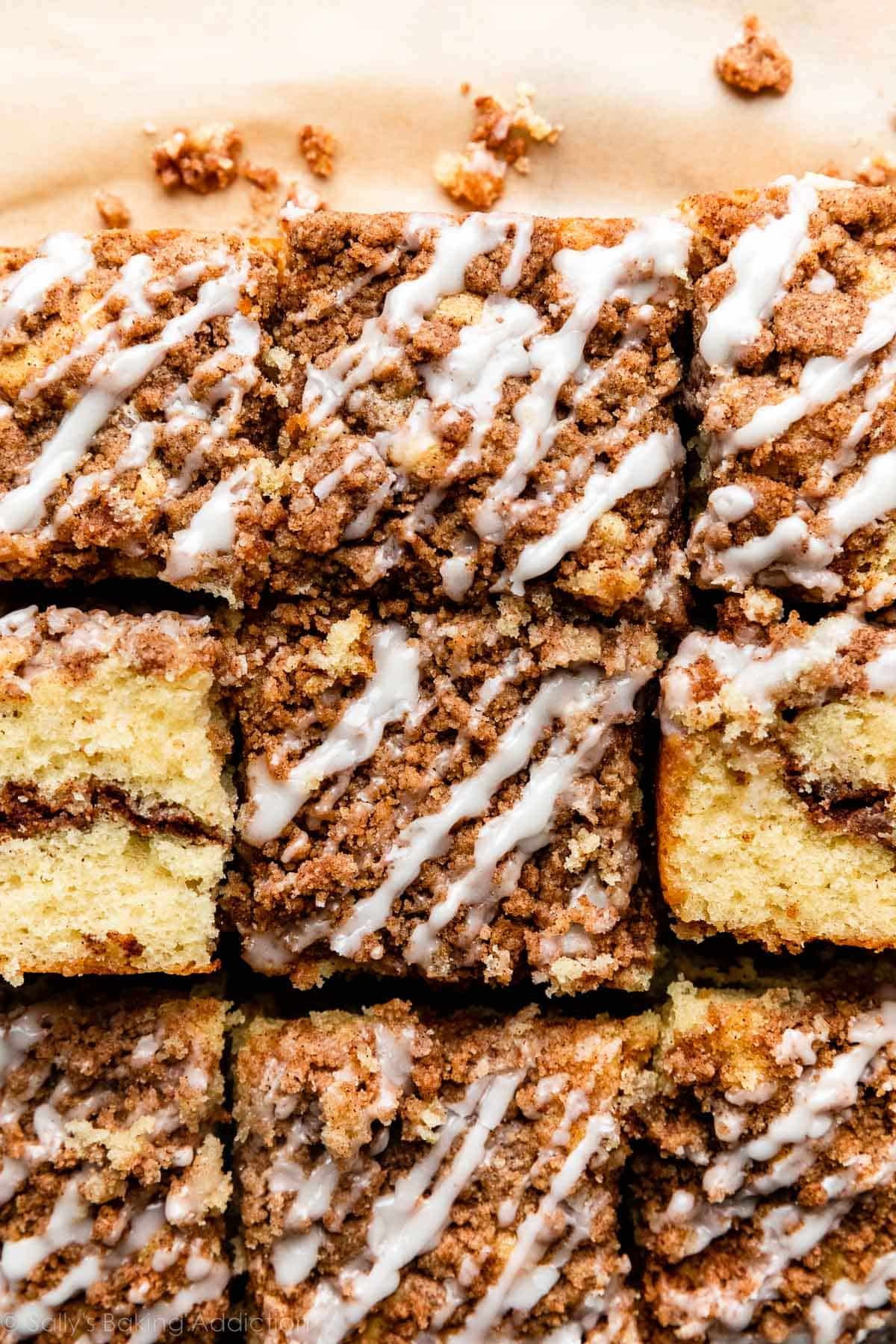 squares of cinnamon crumb coffee cake with vanilla icing on top.