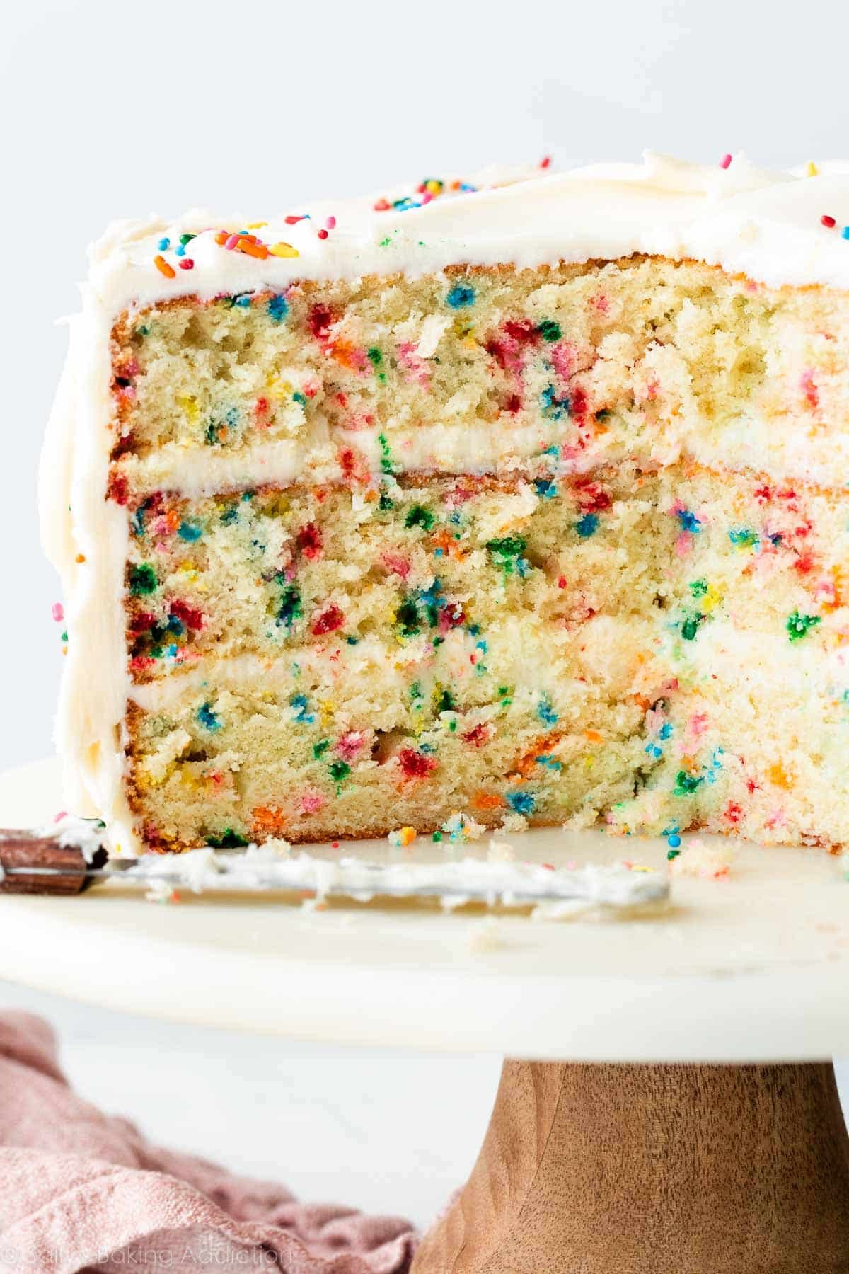 confetti birthday cake cut open to reveal sprinkle-loaded center.