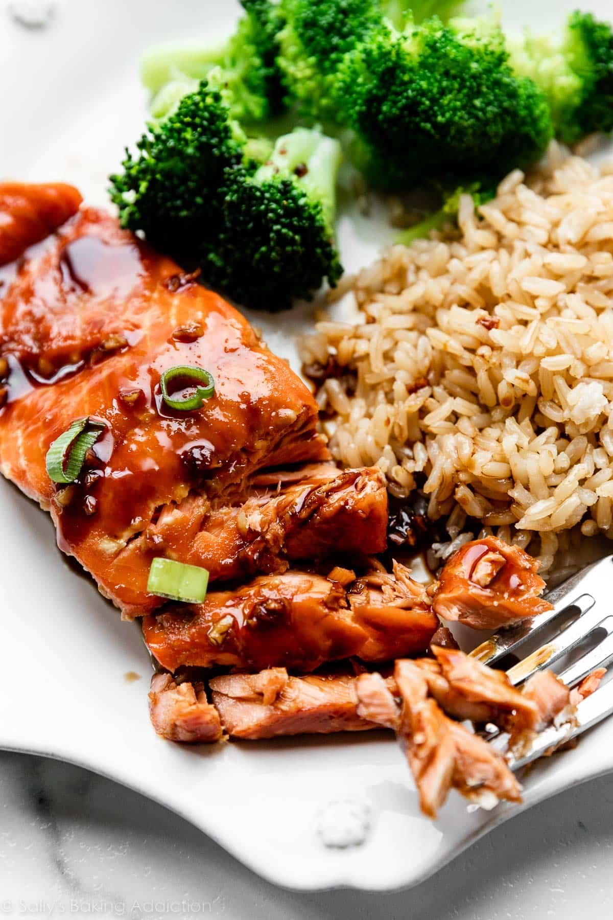 honey garlic glazed salmon on white plate with broccoli and rice.