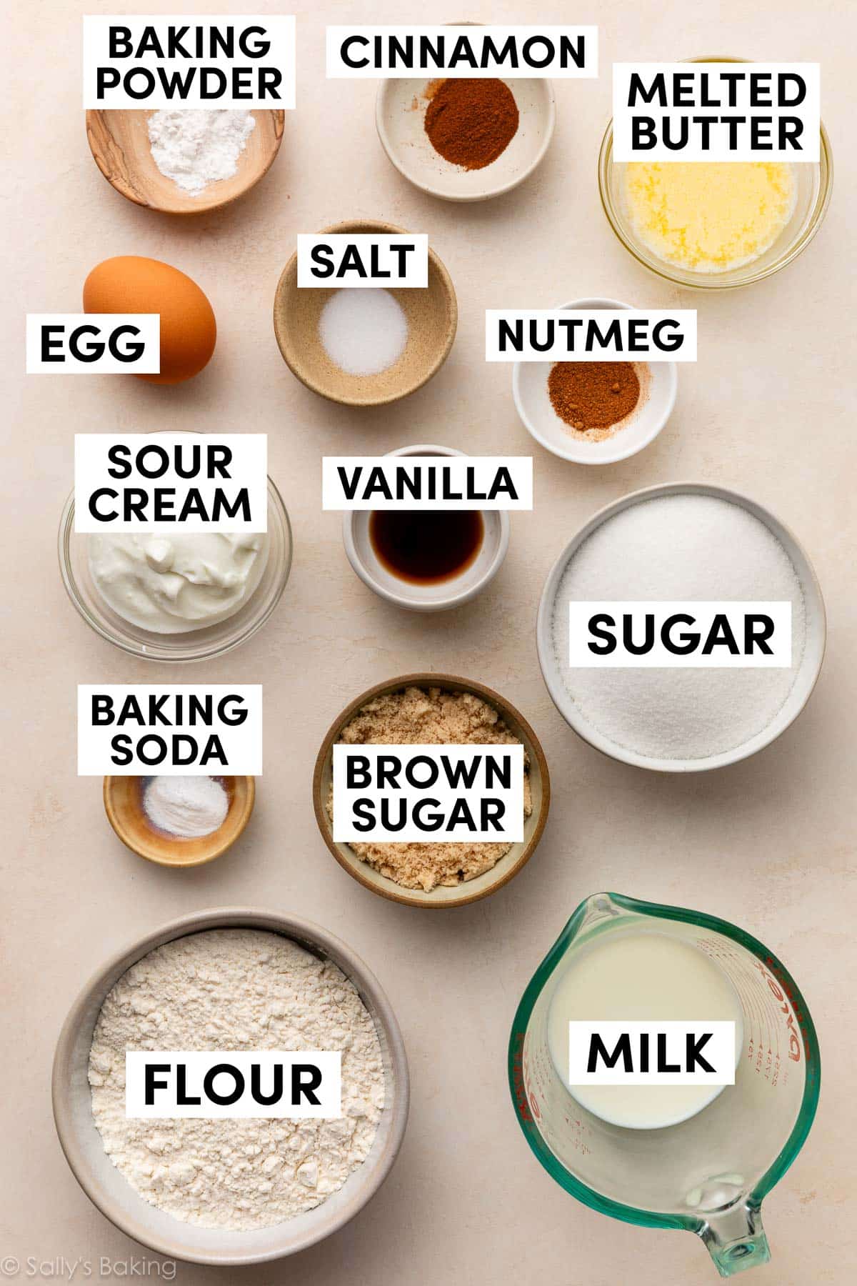 ingredients in bowls including melted butter, milk, flour, sugar, brown sugar, baking soda, sour cream, baking powder.