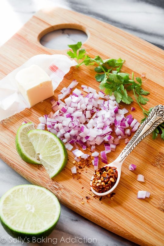ingredients for creamy cilantro lime sauce on a wood cutting board