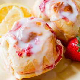 strawberry sweet rolls with lemon glaze on a cream plate