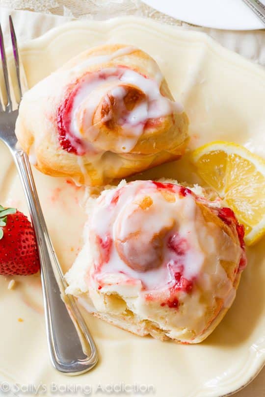 strawberry sweet rolls with lemon glaze on a cream plate with a fork