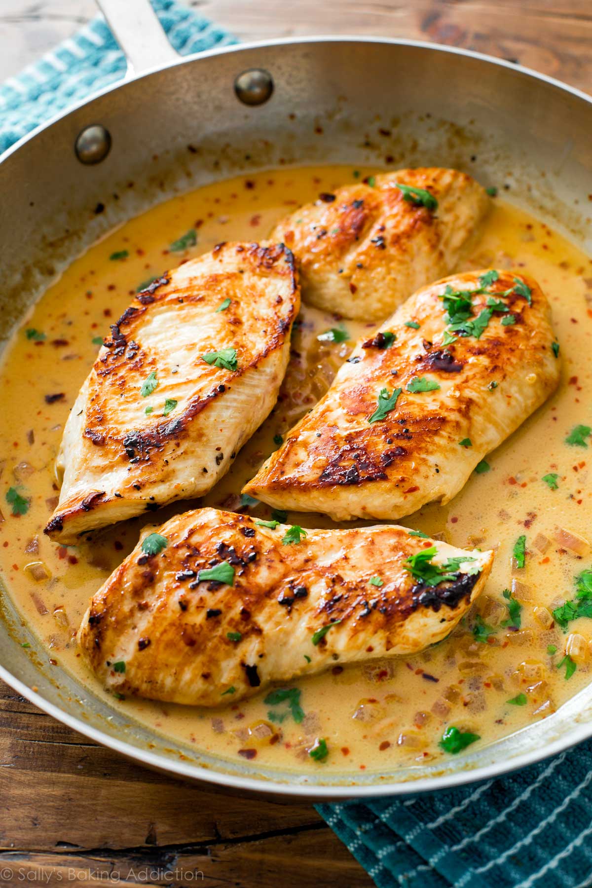 chicken breasts in a skillet with cilantro lime sauce